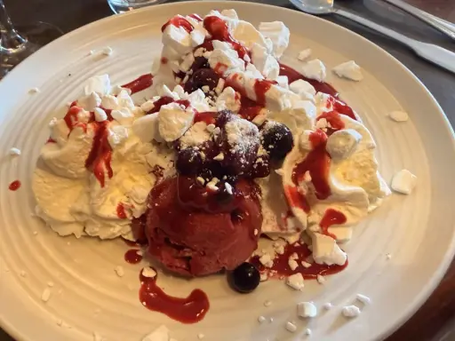 Délicieux dessert meringué aux fruits rouges et glace, une gourmandise du relais d'Alsace Laval.