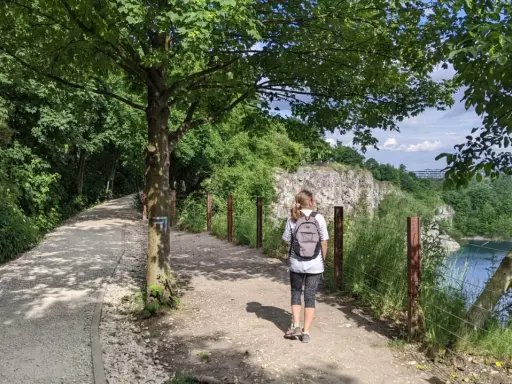 Ścieżka w kamieniołomie Liban, idealne miejsce, gdzie na spacer w Krakowie. Kobieta z plecakiem idzie w stronę skalistych zboczy.