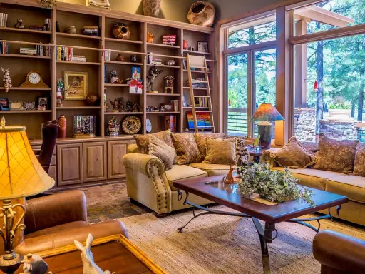 Accogliente soggiorno con libreria in legno, divani imbottiti e un tavolino, perfetto per un arredamento casa campagna.