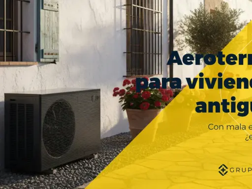 Unidad exterior de aerotermia junto a una casa antigua. ¿Son viables las mentiras de la aerotermia en viviendas antiguas con mala eficiencia?