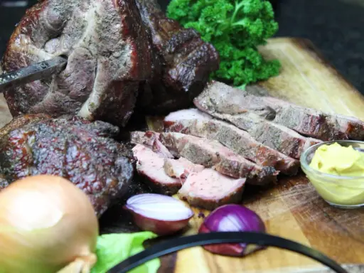 Saftiger Mutzbraten, frisch aufgeschnitten, mit Senf, Zwiebeln und Petersilie. Ein tolles Rezept für den Grill.