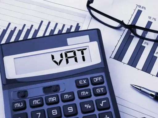 Kalkulator z napisem VAT, wykresy i okulary. Analiza zwolnienia podmiotowego z VAT.