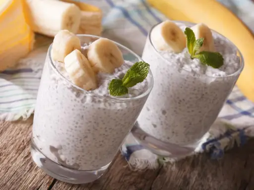 Dwa pucharki z puddingiem z nasion chia i bananem, idealne dla kobiet w ciąży. Zdrowe i pyszne!