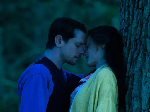 Intymny moment między parą w lesie, przypominający scenę z filmu "Kochanek Lady Chatterley" 2015.
