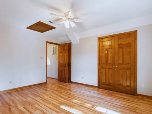 Habitación con suelo de madera clara y puertas de madera oscura, creando un contraste cálido.