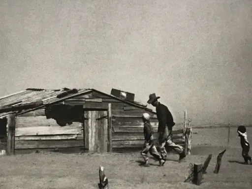 Dust Bowl migrants walk past a dilapidated shack in this iconic Arthur Rothstein photo, a stark reminder of hardship.