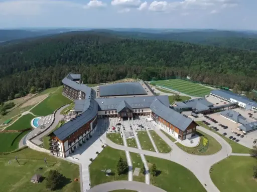 Hotel Arłamów, dzieło wizjonerskiego właściciela, w otoczeniu zielonych wzgórz. Kompleks hotelowy z basenem i boiskiem piłkarskim.