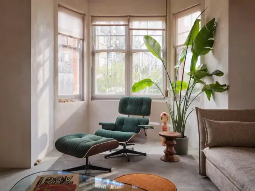 Gemütliche Ecke im **mid century style** mit einem grünen Cord-Sessel, Fußhocker, einer großen Pflanze und einem Sofa.