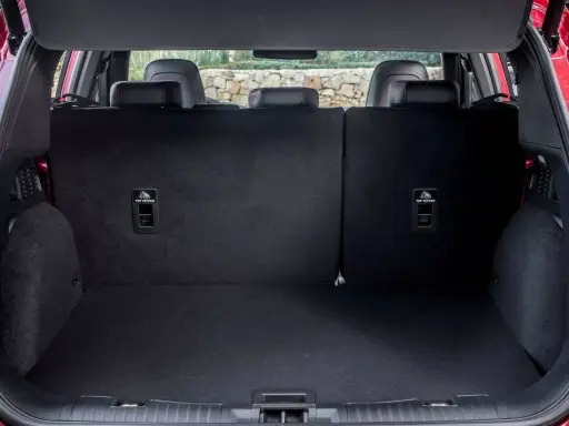 Maletero del Ford Kuga con asientos abatidos, listo para cargar equipaje o compras. Se aprecian los anclajes ISOFIX.