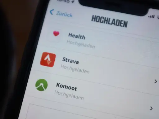 Na ekranie telefonu widać aplikację Strava po polsku, obok Health i Komoot.