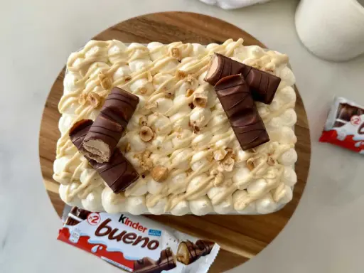 Un délicieux tiramisu Kinder Bueno, garni de morceaux de chocolat et de noisettes concassées. Un vrai régal pour les gourmands !