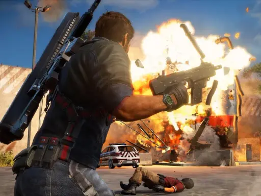 Rico Rodriguez strzela z pistoletu maszynowego, wywołując eksplozję. W tle radiowóz i powalony przeciwnik. Just Cause 3 wymagania.