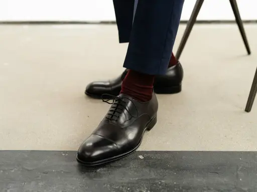 Eleganckie, czarne oksfordy to klasyczne rodzaje męskich butów. Wygodne, z bordowymi skarpetkami, idealne na formalne okazje.