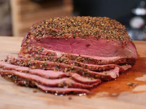 Perfekt gegrilltes Roastbeef mit kräftiger Gewürzkruste, saftig rosa geschnitten auf einem Holzbrett. Ein Genuss für jeden Grillmeister!