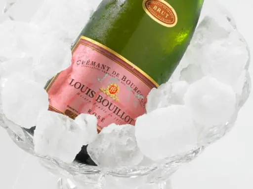 Flasche Louis Bouillot Rosé Crémant de Bourgogne in Eis gekühlt, perfekte Champagner Temperatur.