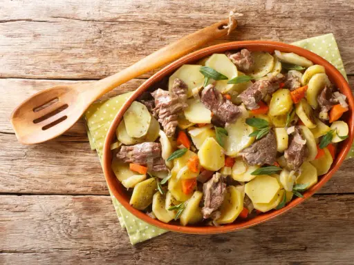 Un plat de pommes de terre et de viande mijotée, garni d'herbes fraîches, une spécialité alsace réconfortante.