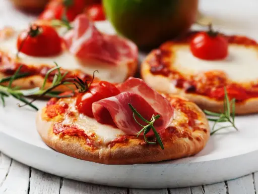 Pizzerinki z serka wiejskiego, pomidorkami koktajlowymi i szynką parmeńską, ozdobione rozmarynem.