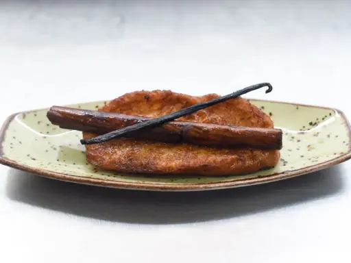 Torrijas de leche y canela, doradas y crujientes, con una rama de canela y vainilla. ¡Perfectas para aprender como hacer torrijas de leche y canela!