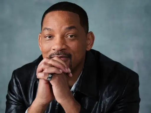 Will Smith, känd från många filmer och tv-program, sitter med händerna knäppta framför sig.