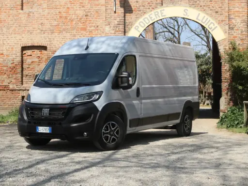 Srebrny Fiat Ducato Maxi stoi przed ceglanym murem i łukiem z napisem "PODERE S. LUIGI".