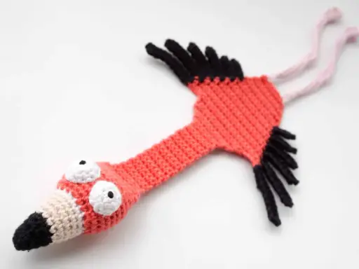 Flamenco amigurumi hecho a mano, con ojos saltones y pico bicolor. ¡Un patrón gratis para crear tu propio flamenco!