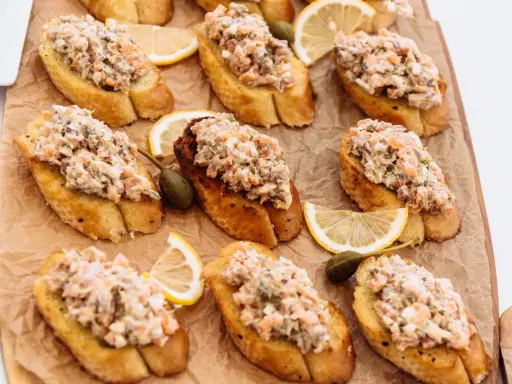 Bruschettas garnies de rillettes de sardines, câpres et quartiers de citron. Un délice pour l'apéritif.