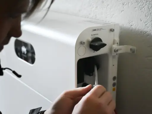 Person kopplar in en kabel i ett vitt system för att lagra solenergi batteri.