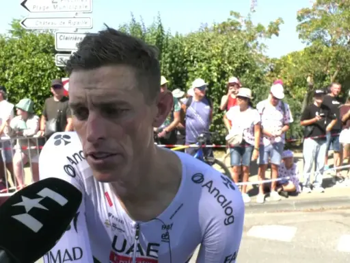 Brandon McNulty, Radfahrer im UAE-Trikot, gibt ein Interview. Im Hintergrund stehen Zuschauer und Straßenschilder.