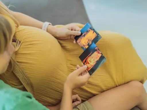 Dziecko na zdjęciach usg 3d, które trzymają mama i starsze rodzeństwo.