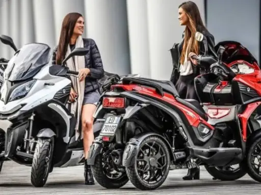Dos mujeres posan junto a dos motos de cuatro ruedas, ideales para quienes tienen carnet B y buscan una experiencia de conducción diferente.