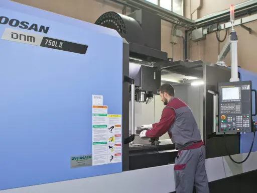 Operaio lavora su centro di lavoro CNC, strumento essenziale per il software progettazione e la produzione di precisione.