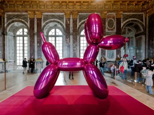 Jeff Coons' glänzender Ballonhund in Pink, ausgestellt in einem prunkvollen Saal mit Besuchern.