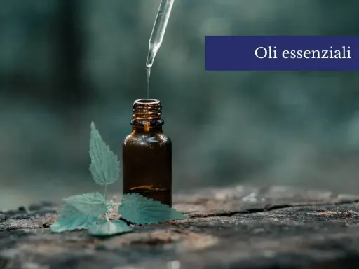 Una goccia di olio essenziale cade da un contagocce in una bottiglia ambrata, accanto a una foglia verde. Scopri come usare gli oli essenziali sulla pelle per un benessere naturale.