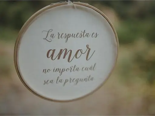 Bordado con "La respuesta es amor, no importa cuál sea la pregunta", ideal para frases cortas para felicitar bodas.