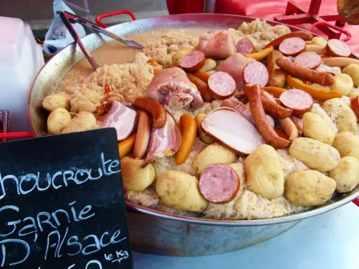 Choucroute garnie d'Alsace, une spécialité alsacienne généreuse avec saucisses, lard, porc et pommes de terre sur choucroute.