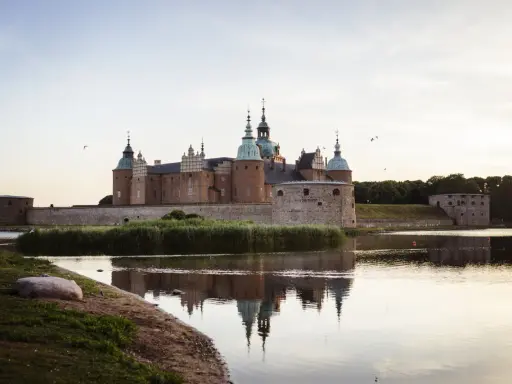 Kalmar Slott, ett populärt utflyktsmål, speglar sig i vattnet en stilla kväll.