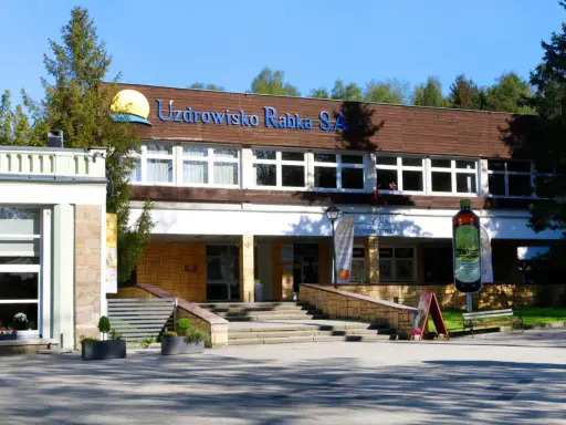 Sanatorium Jagiellonka w Rabce-Zdroju, budynek z napisem "Uzdrowisko Rabka S.A." i dużą butelką solanki.