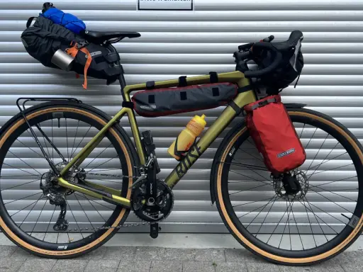 Gravelbike mit Packtaschen für Bikepacking. Das Zelt ist im Satteltaschen-Setup verstaut, bereit für das nächste Abenteuer.