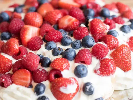 En härlig pavlova med vispgrädde och massor av färska bär. Ett perfekt pavlova recept för sommaren!