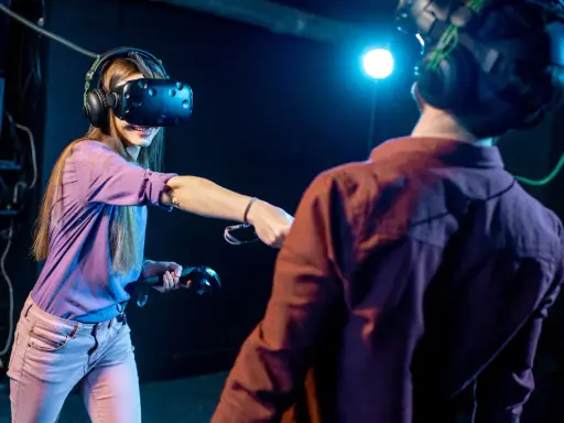 Para grająca w gry na Google VR, zanurzona w wirtualnej rzeczywistości, z kontrolerami w dłoniach.