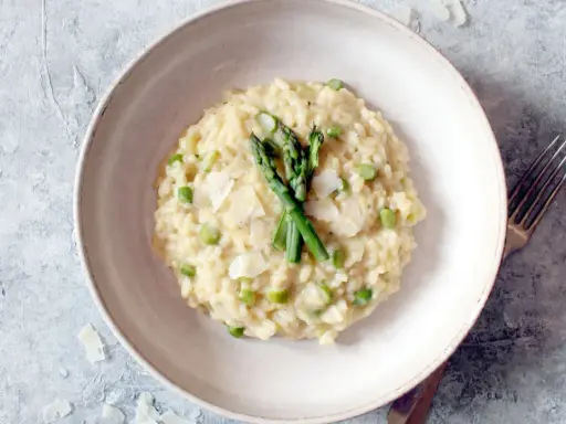Cremiges Spargel-Erbsen-Risotto, garniert mit frischem Spargel und Parmesan. Ein Beweis für die besten Risotto Rezepte.