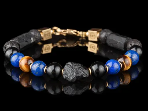 Bransoleta z lapis lazuli i kamienia wulkanicznego, ozdobiona złotymi elementami. Idealna dla osób szukających swojego znaku zodiaku.