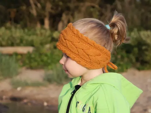 Niña con diadema de lana tejida, ideal para aprender como hacer diademas de lana para niñas.