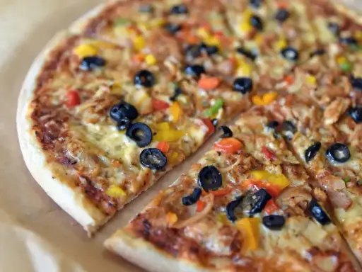 Pyszna pizza z oliwkami i kolorową papryką, jeden z wielu apetycznych rodzajów pizzy.