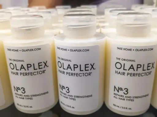 Reihen von Olaplex Hair Perfector No. 3 Flaschen, die bei Haarausfall helfen.