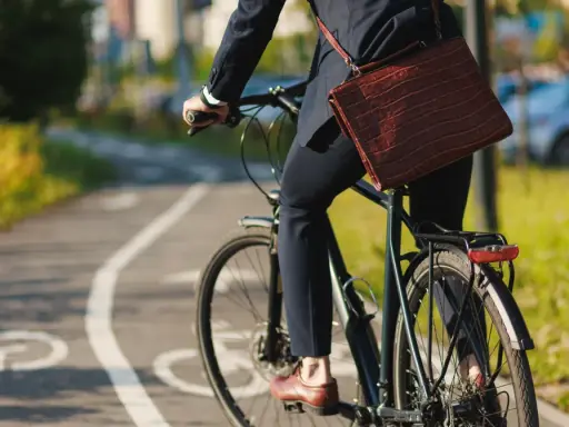 Biznesmen na rowerze, jadący ścieżką rowerową. Zastanawia się, ile promili na rowerze jest dopuszczalne, by bezpiecznie dotrzeć do celu.