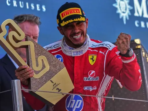 Hamilton im Ferrari-Outfit jubelt mit Pokal.