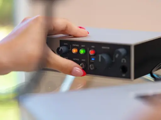 Dłoń z czerwonym lakierem na paznokciach dotyka panelu urządzenia, pokazując jak podłączyć mio smartbox iii.