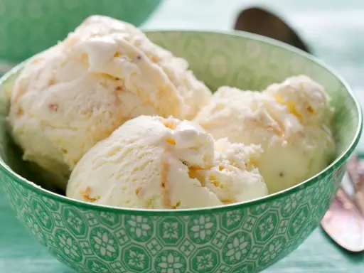 Kremowe lody z mascarpone w zielonej miseczce, idealne na upalny dzień.