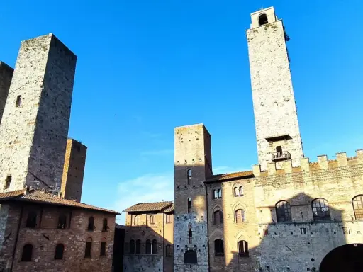 Wieże średniowiecznego miasta San Gimignano wznoszą się dumnie pod błękitnym niebem.